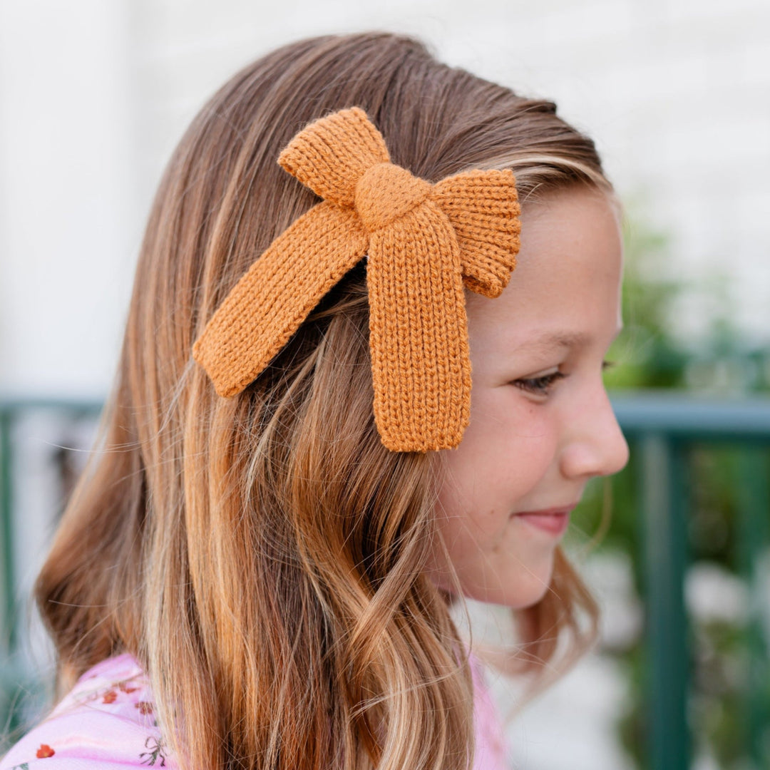 little girl in mustard knit bow on clip and pink velvet floral top for fall