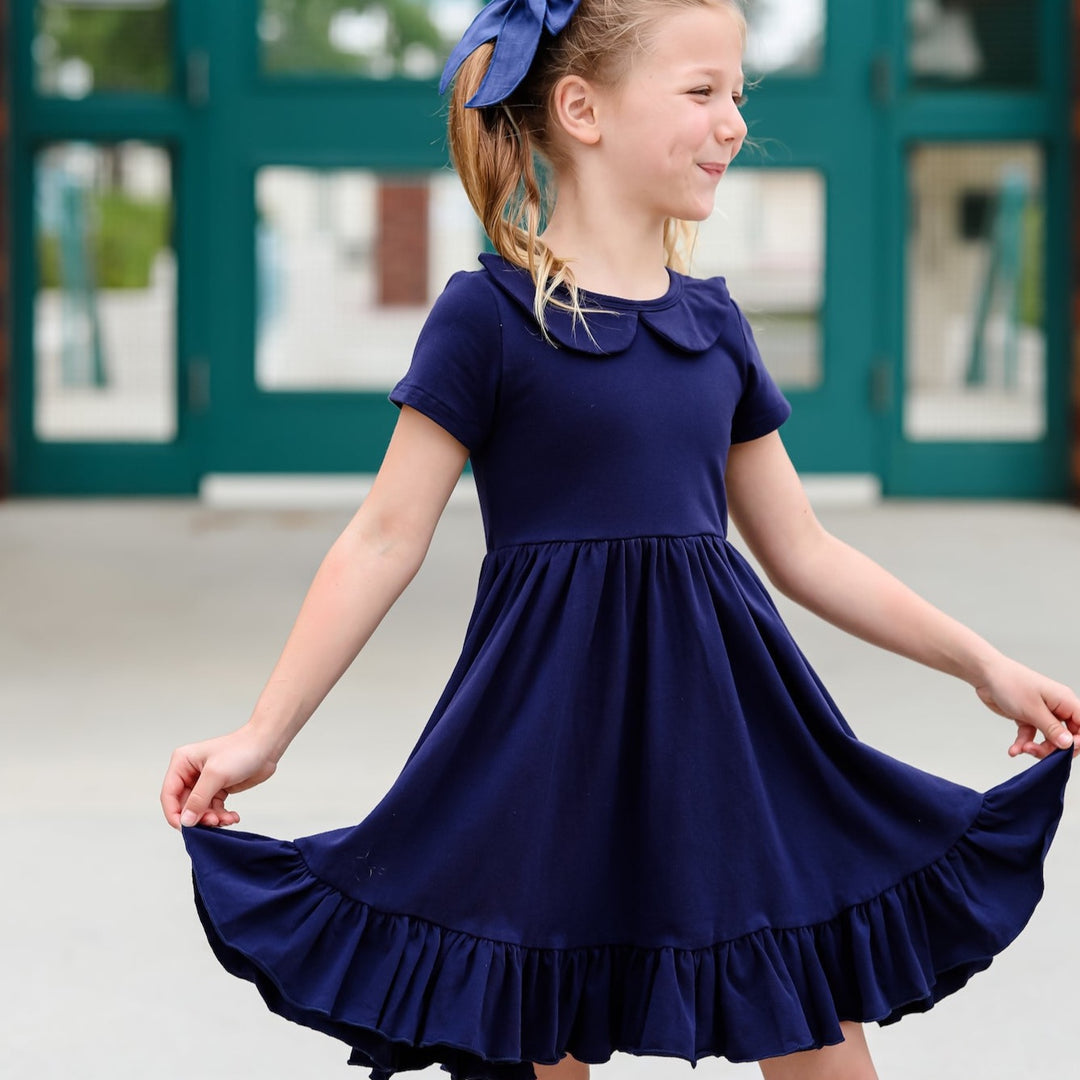 girl wearing navy blue uniform dress with peter pan collar for back to school
