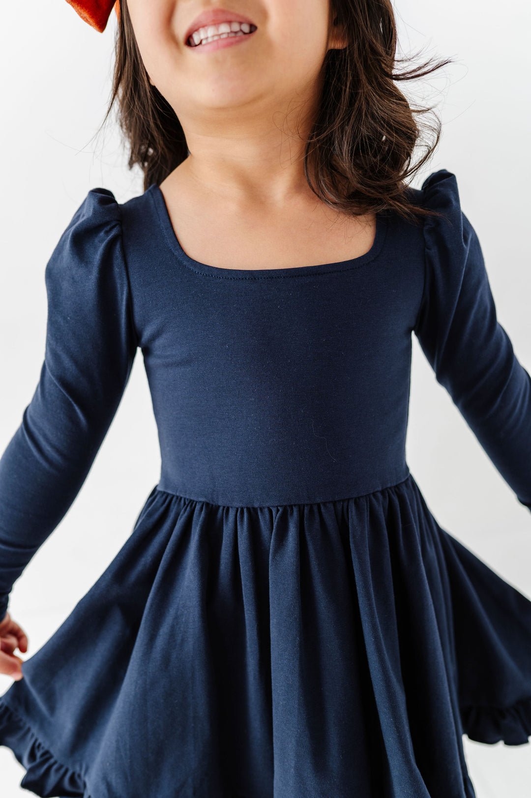 little girl wearing long sleeve navy twirl dress with square neckline