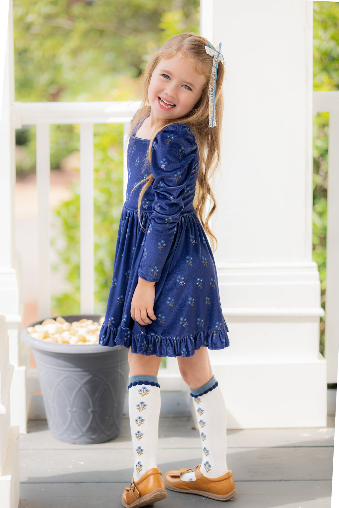 little girl in navy blue floral long sleeve velvet twirl dress with matching floral knee socks and lace hair bow for fall