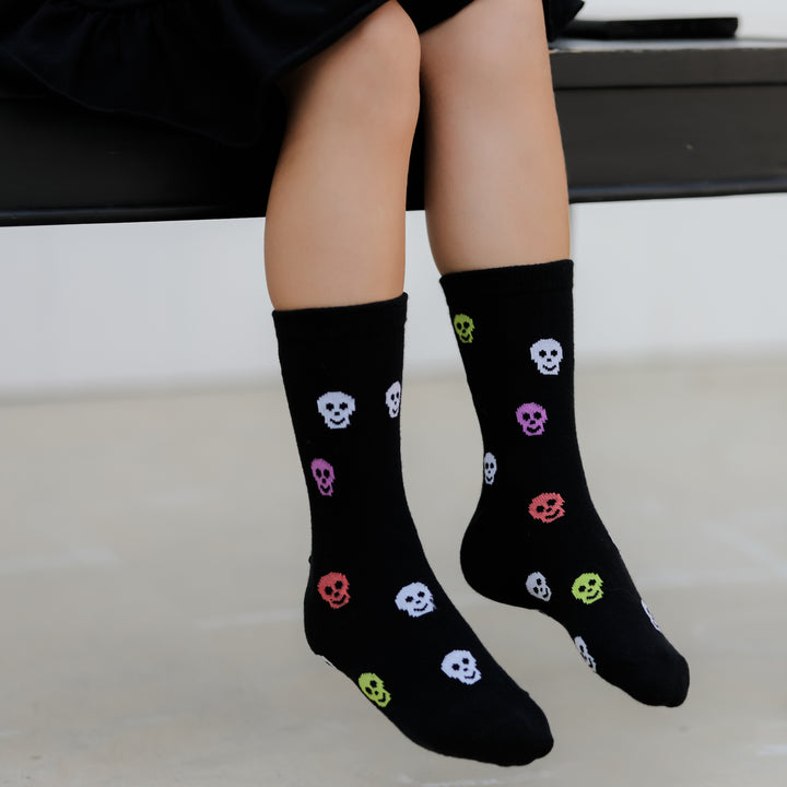 little girl wearing neon skull halloween socks