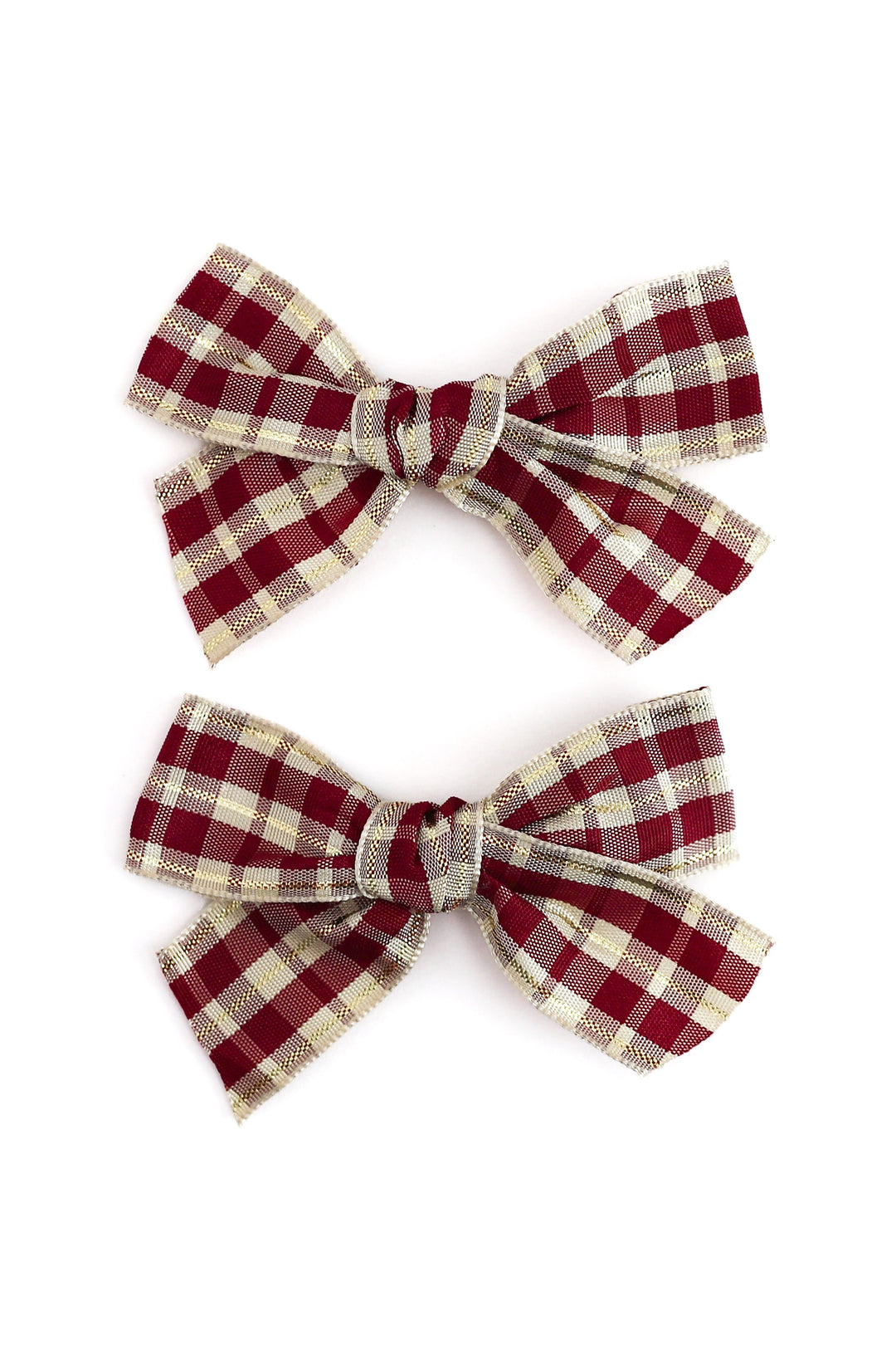 Two matching fabric hair bows with a red and beige gingham plaid pattern, arranged vertically on a plain white background.