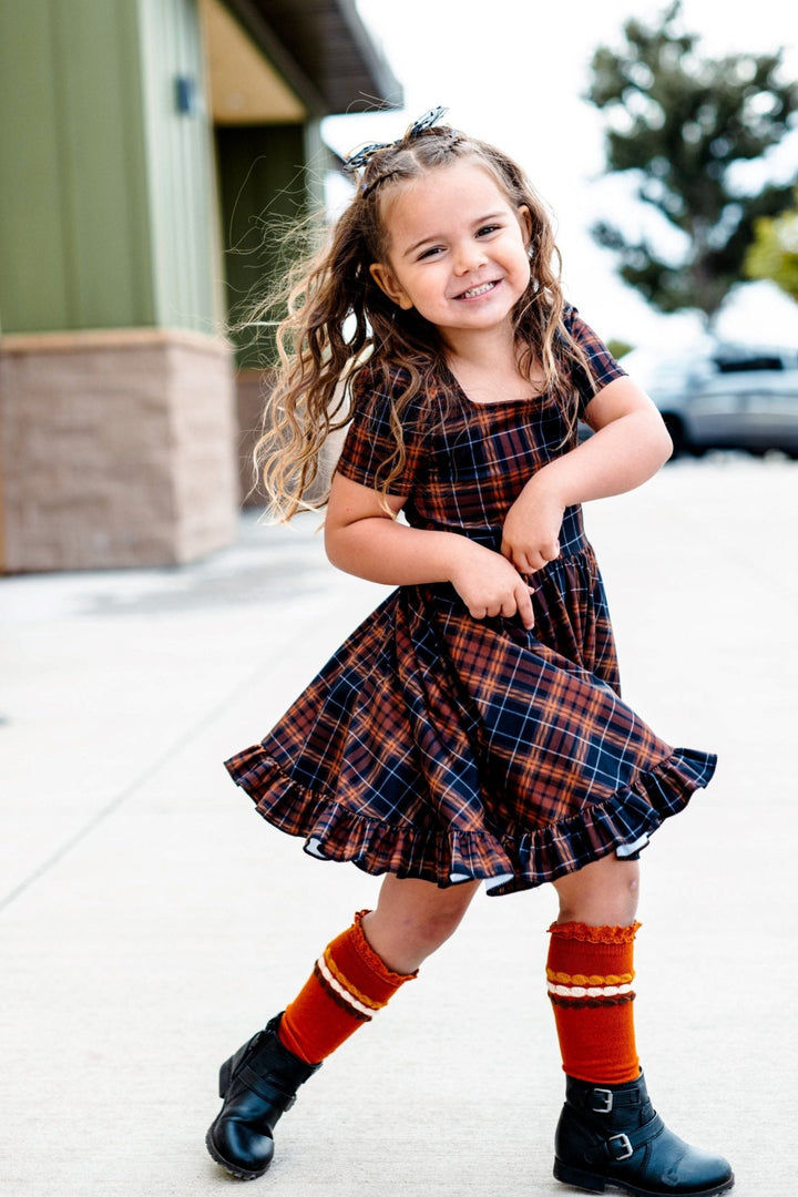 little girl in fall plaid square neck twirl dress with matching pumpkin spice knee highs