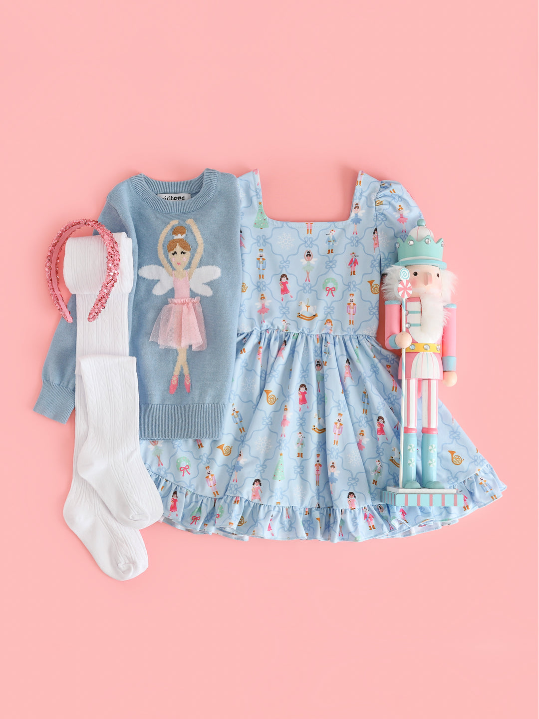 girls' nutcracker inspired Christmas outfit featuring blue nutcracker print twirl dress, matching blue sugarplum fairy sweater, white crochet tights and sparkly pink headband