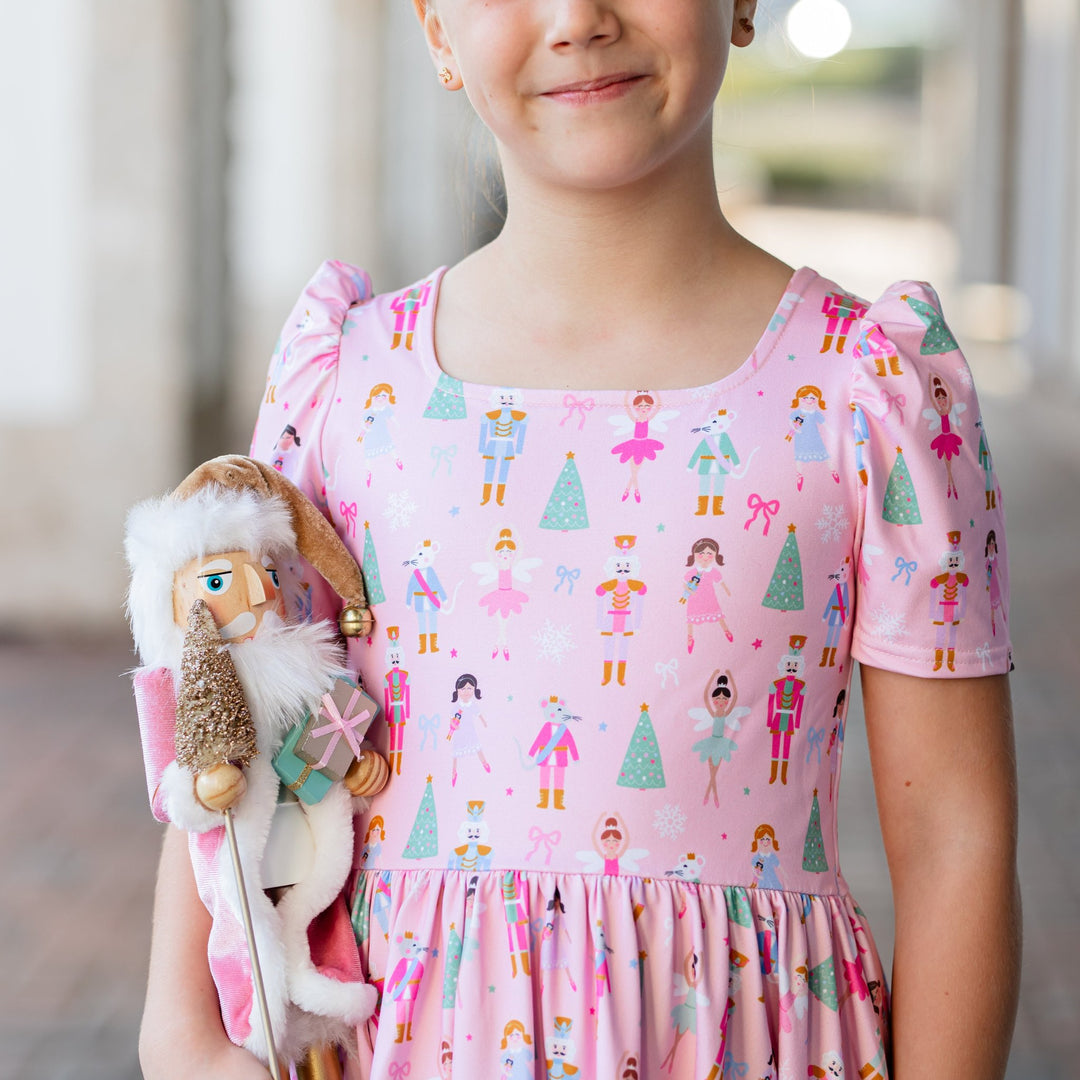 closeup of girls square neck holiday twirl dress with pastel nutcracker print