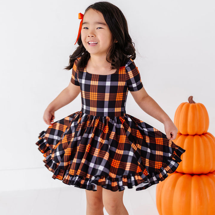 little girl in halloween plaid twirl dress