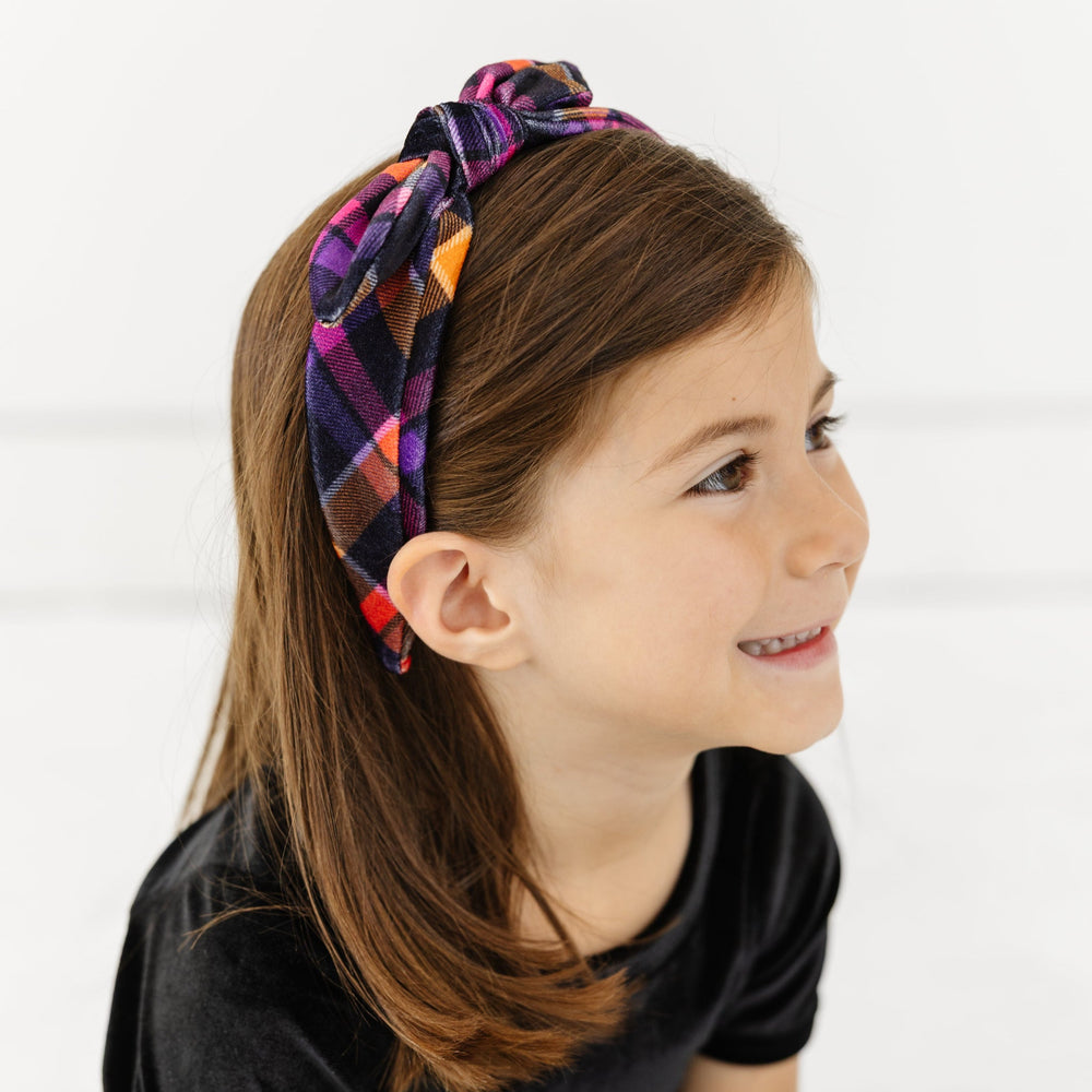 little girl in velvet plaid bow headband in Halloween colors paired with black velvet fitted top and skort
