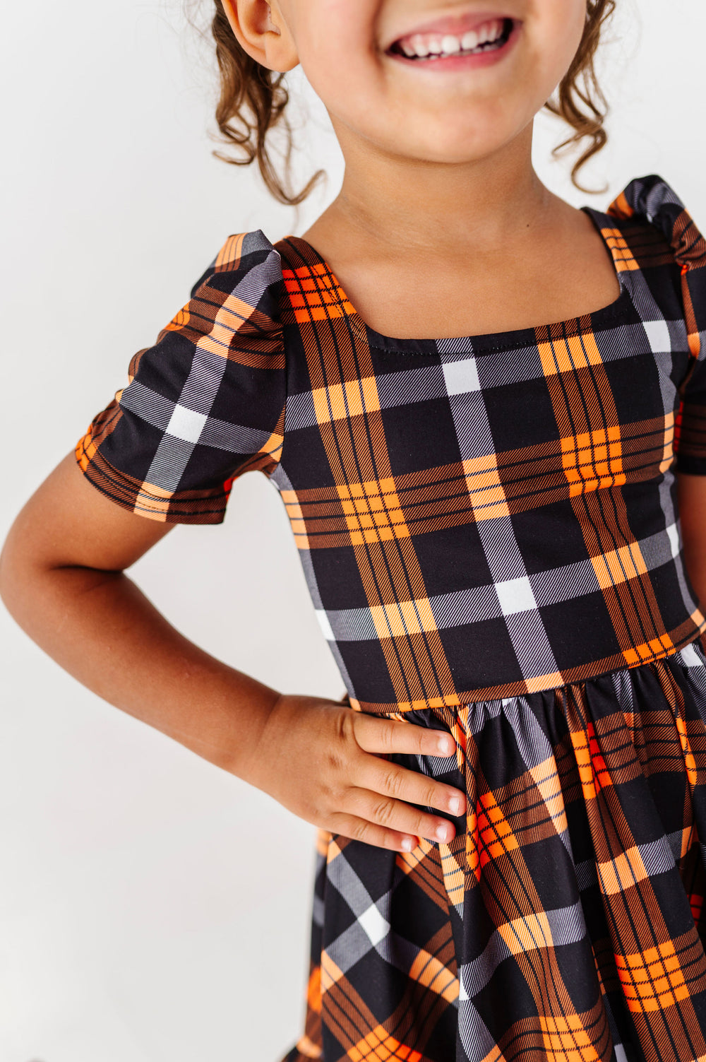 detail of black and orange plaid dress for girls