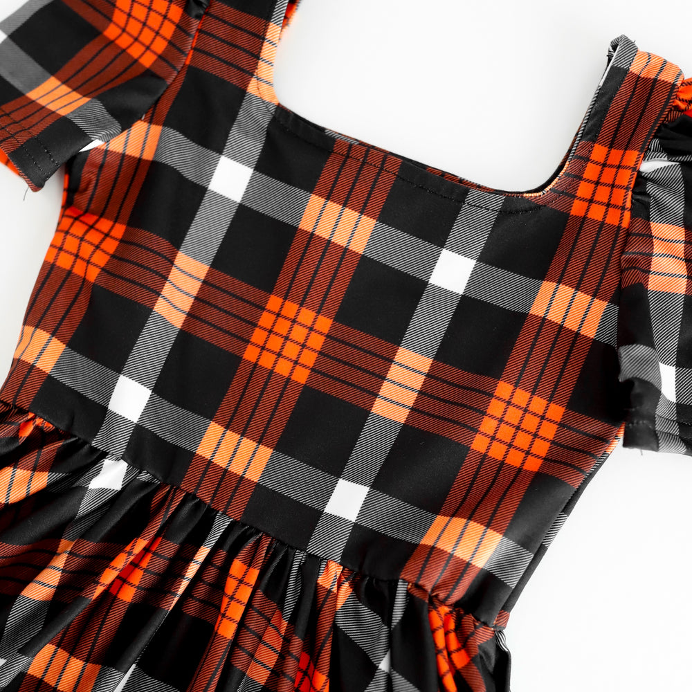 closeup of black and orange plaid print twirl dress bodice for Halloween