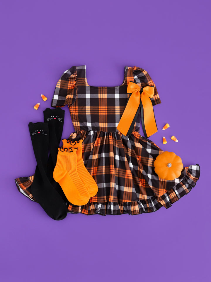 girls square neck orange and black plaid Halloween dress paired with orange and black socks and bow