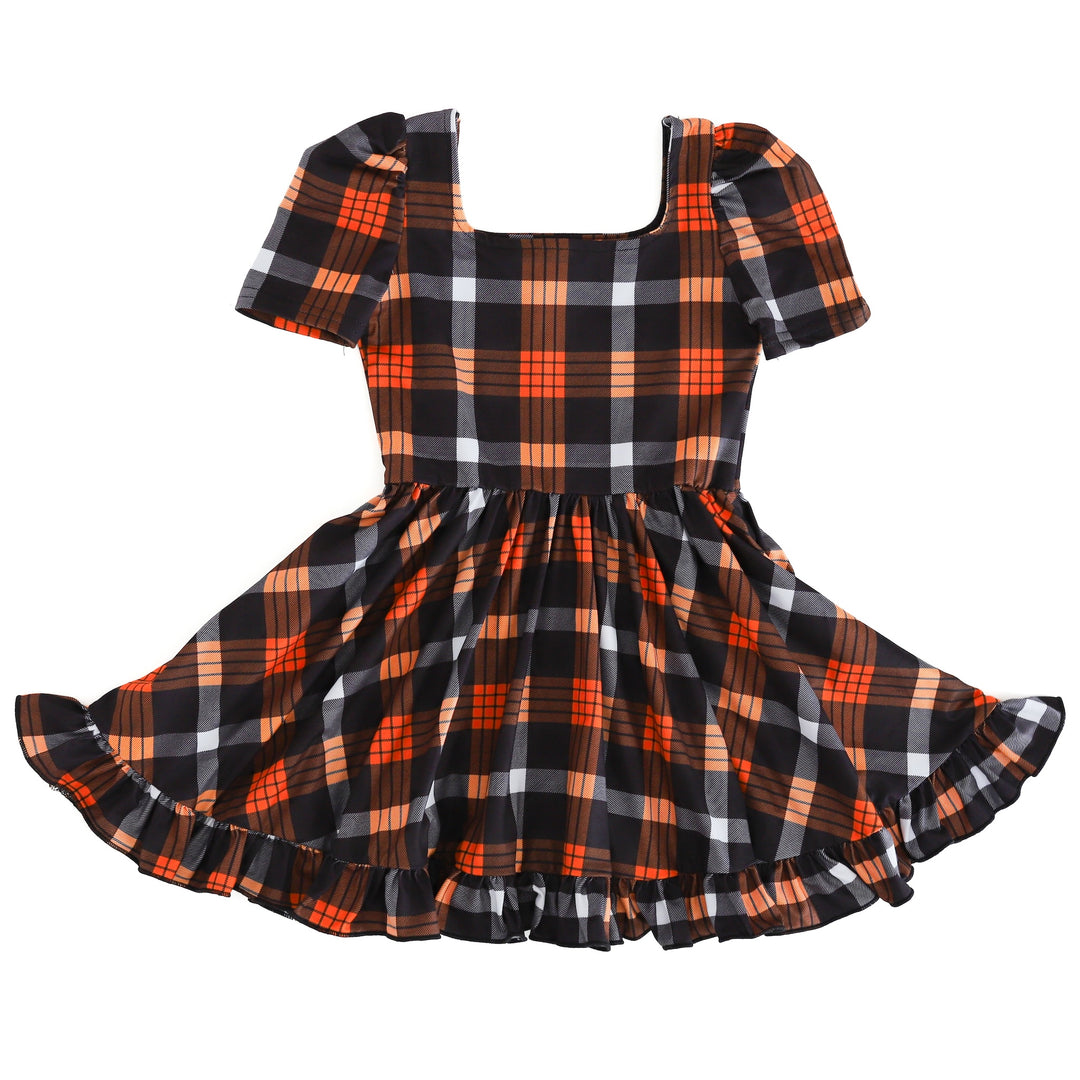 girls black and orange plaid print twirl dress with square neckline, short puffed sleeves and ruffled hem on clean white background