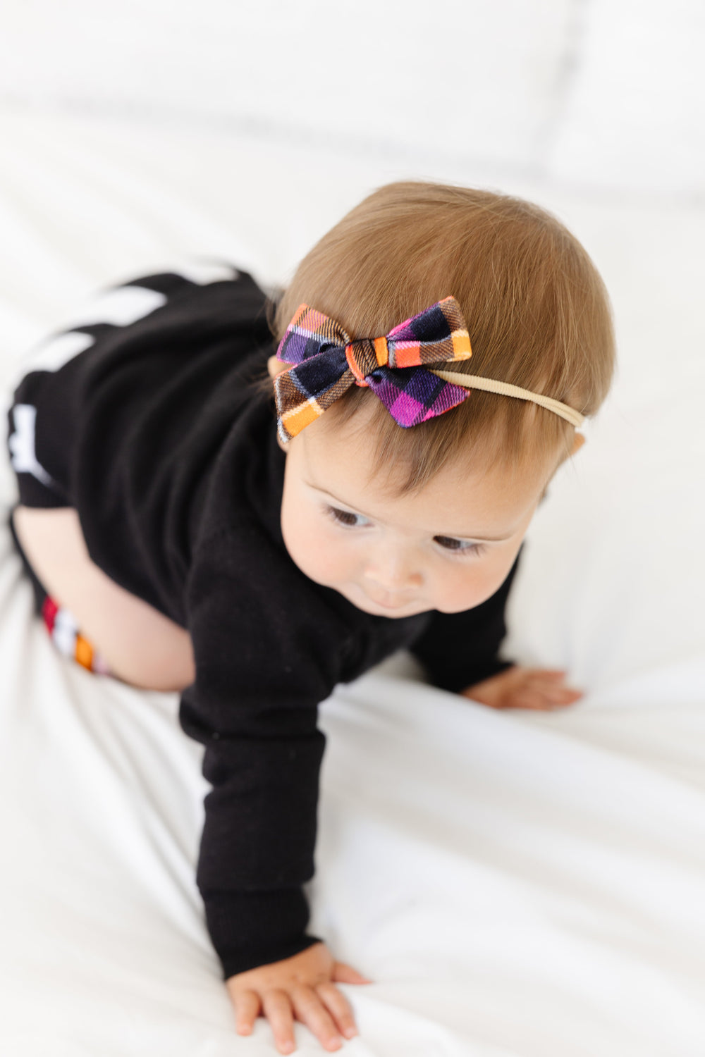 baby girl crawling in black and white sweater set with velvet plaid bow on nylon headband