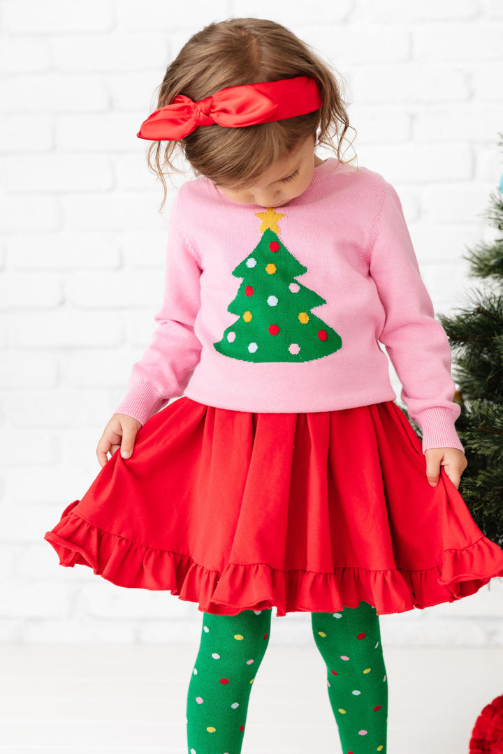 little girl in pink holiday sweater with polka dot Christmas tree design with matching red dress, headband and polka dot tights