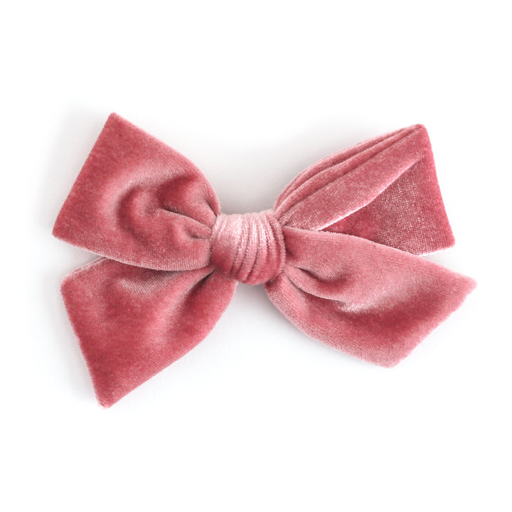 A dusty rose velvet bow hair clip on a clean white background.