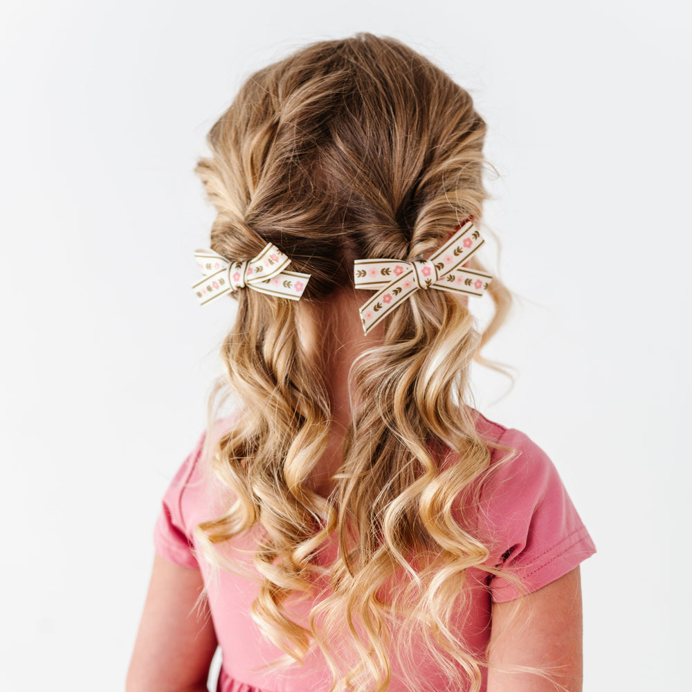 little girl in olive and fall pink posey print ribbon pigtail bows on clips paired with matching pink twirl dress