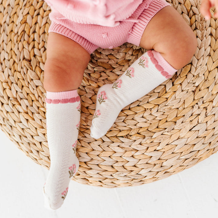 baby girl in ivory knee socks with pink fall floral design and matching pink sweater set