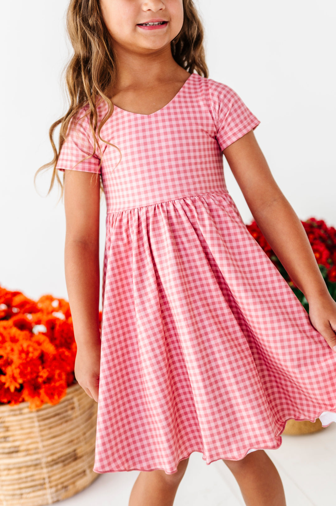 detail photo of little girl in two-tone pink gingham twirl dress with v-neck design