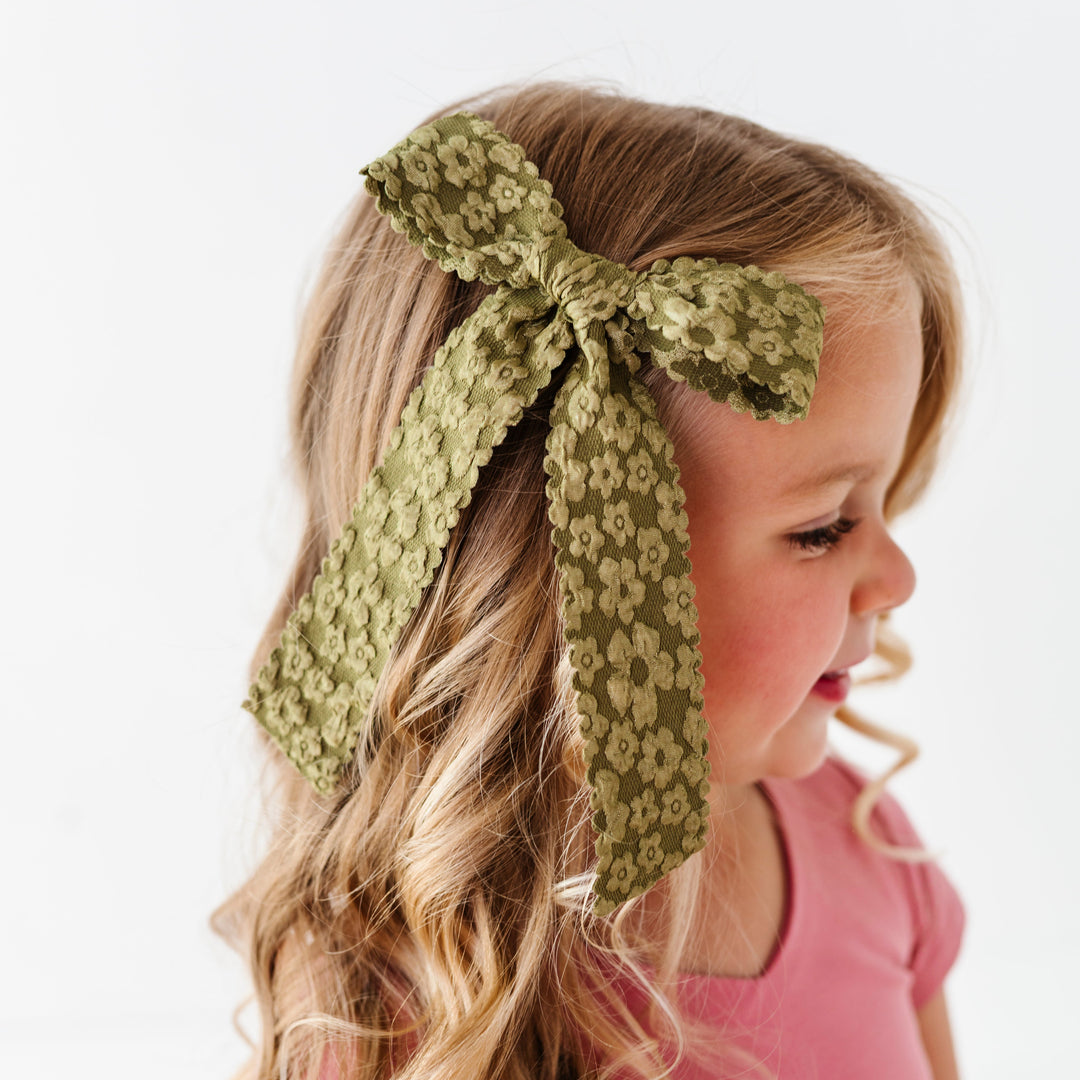 little girl with olive floral scalloped hair bow paired with old rose fall twirl dress