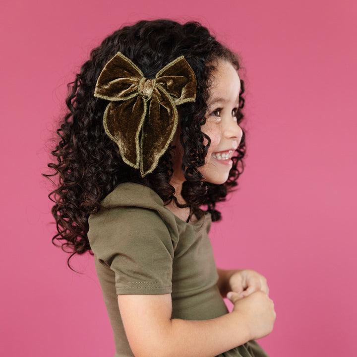 little girl in olive green velvet hairbow on clip and matching cotton twirl in olive green