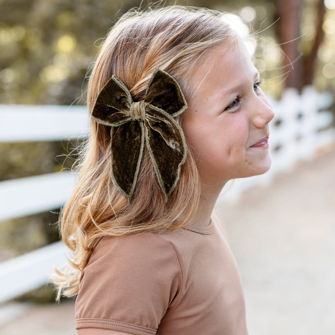 little girl in light brown dress and olive green velvet hairbow on clip