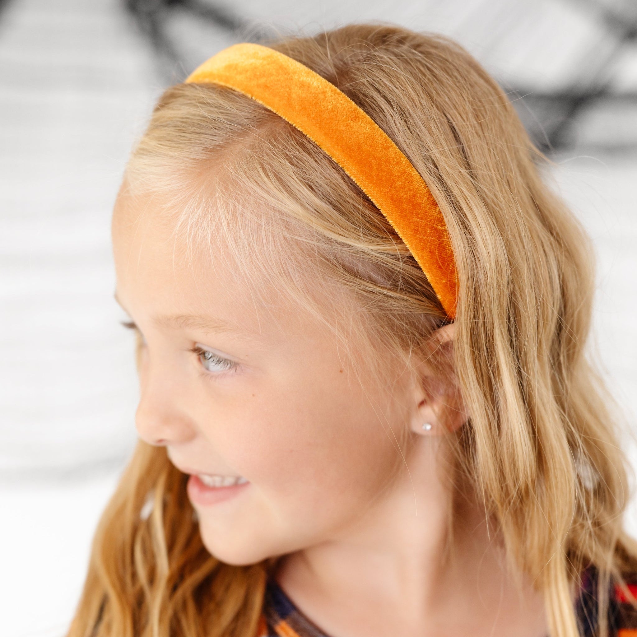 little girl in Halloween velvet plaid twirl dress paired with orange velvet headband  