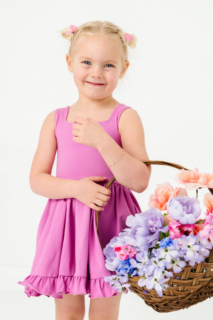 little girl in pigtails holding flower basket in solid orchid cotton blend sleeveless twirl dress