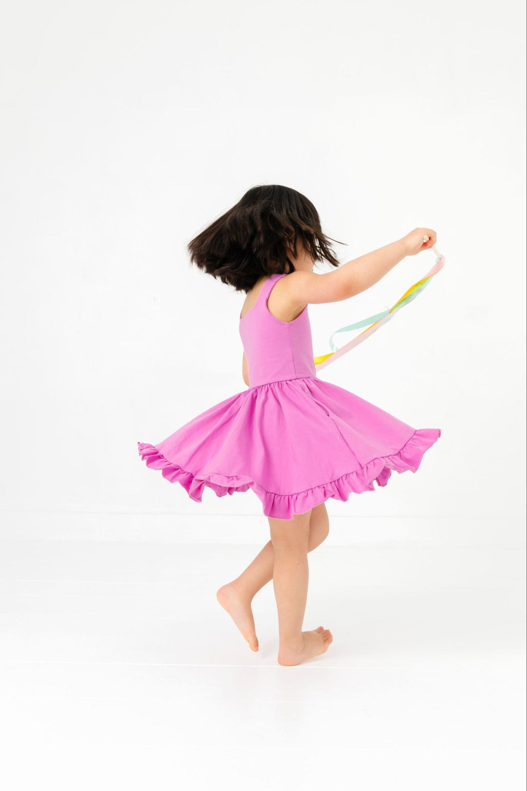 little girl twirling with streamers in sleeveless solid orchid cotton blend twirl dress with ruffled hem