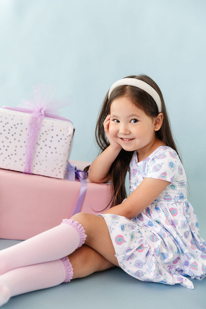 girl wearing pastel ornament print dress with matching purple lace knee highs