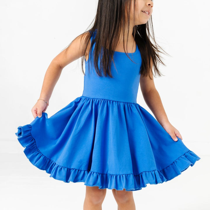 young girl in bright cobalt blue sleeveless twirl dress for summer and fourth of July
