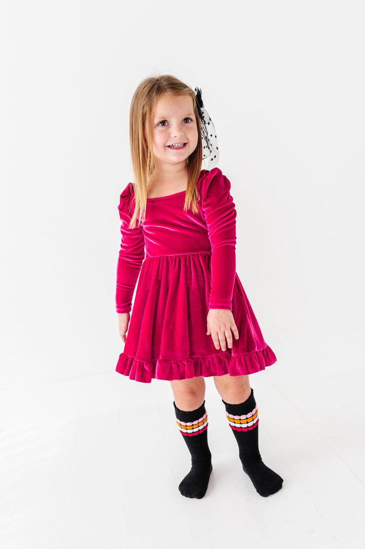 girl wearing bright pink velvet twirl dress