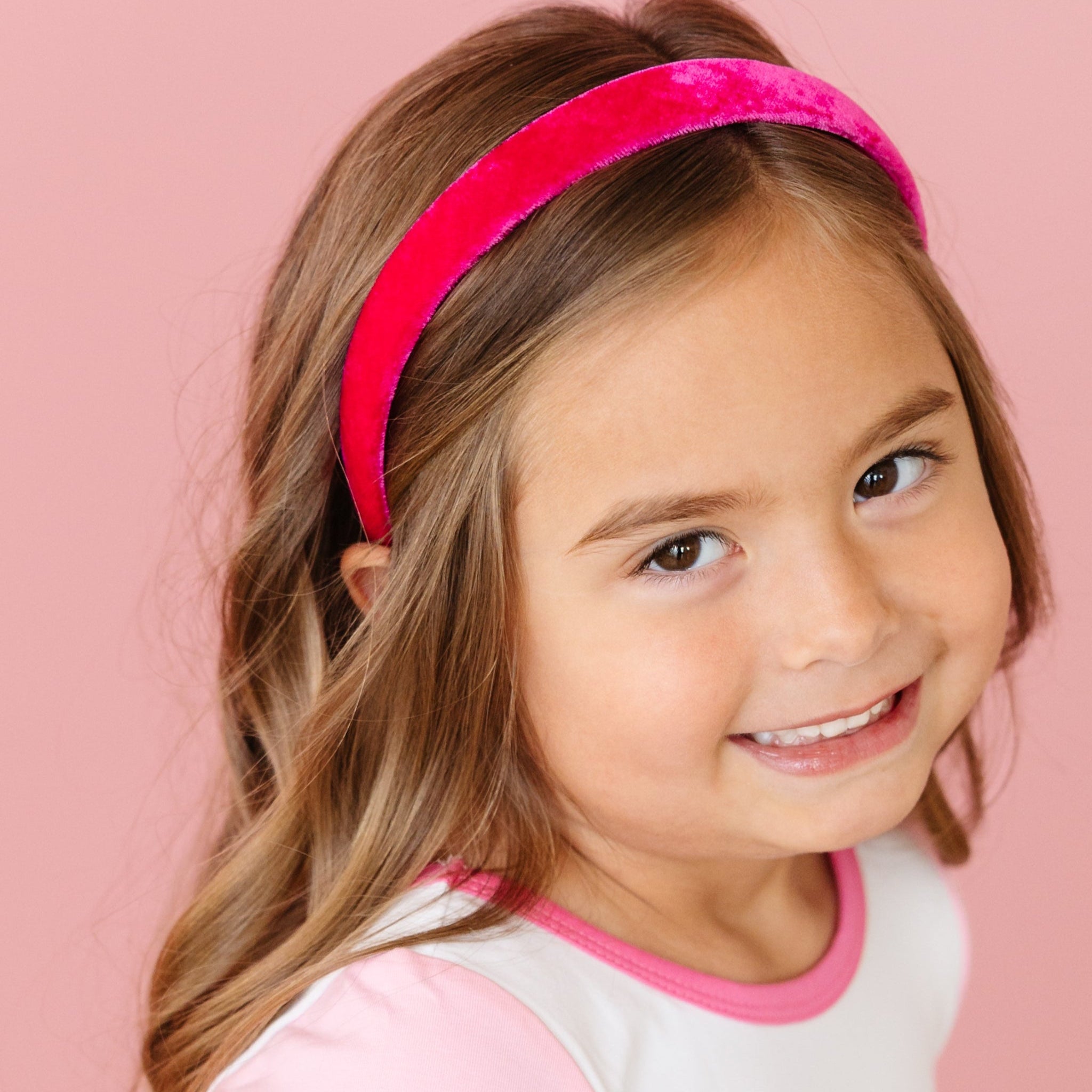 little girl in ghouly pop fitted top with pink short sleeves and matching bright pink velvet headband for pink Halloween
