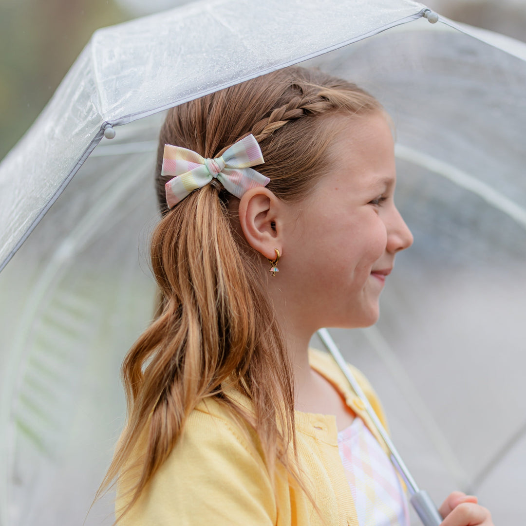 girl with satin pastel rainbow gingham print pigtail bow holding umbrella