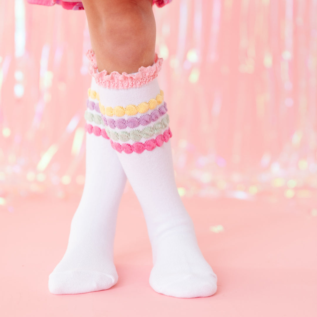 closeup of little girl in white knee high socks with pastel bubble stripe and pink lace trim