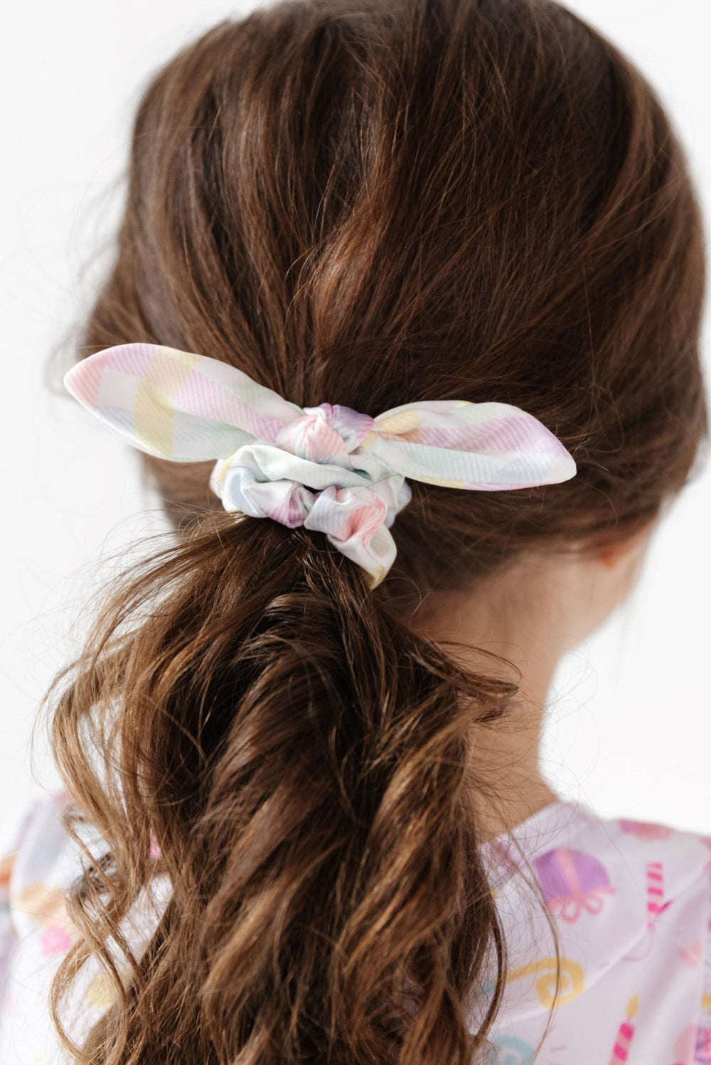 little girl in ponytail styled with satin bow scrunchie in pastel gingham print for birthday and easter outfits