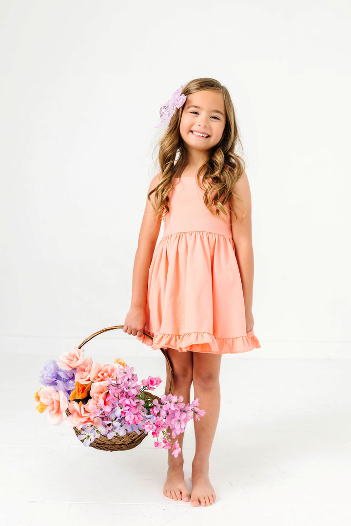 little girl holding flower basket in peach sleeveless square neck summer twirl dress