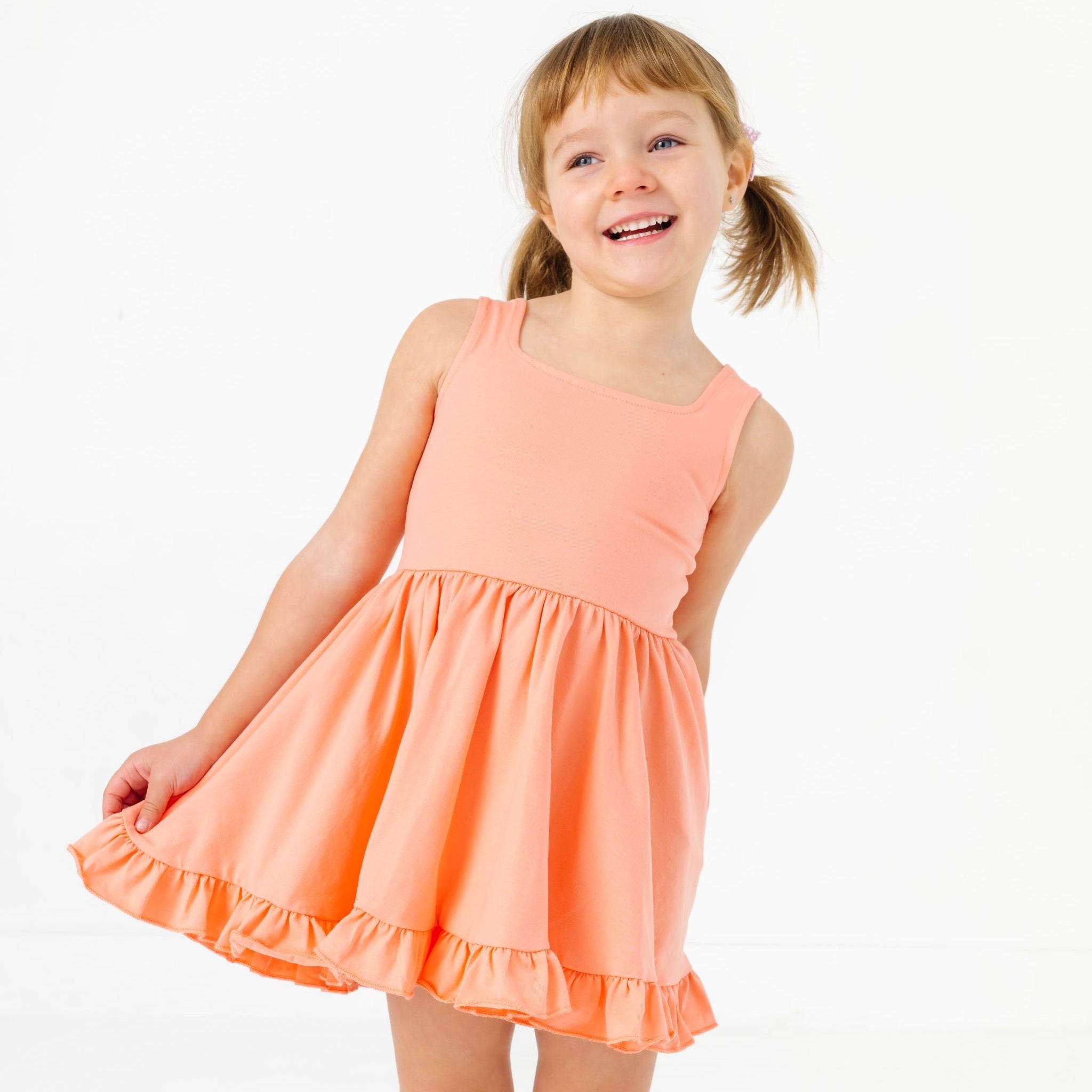 little girl in peach sleeveless square neck summer twirl dress
