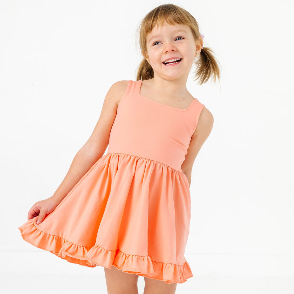 little girl in peach sleeveless square neck summer twirl dress