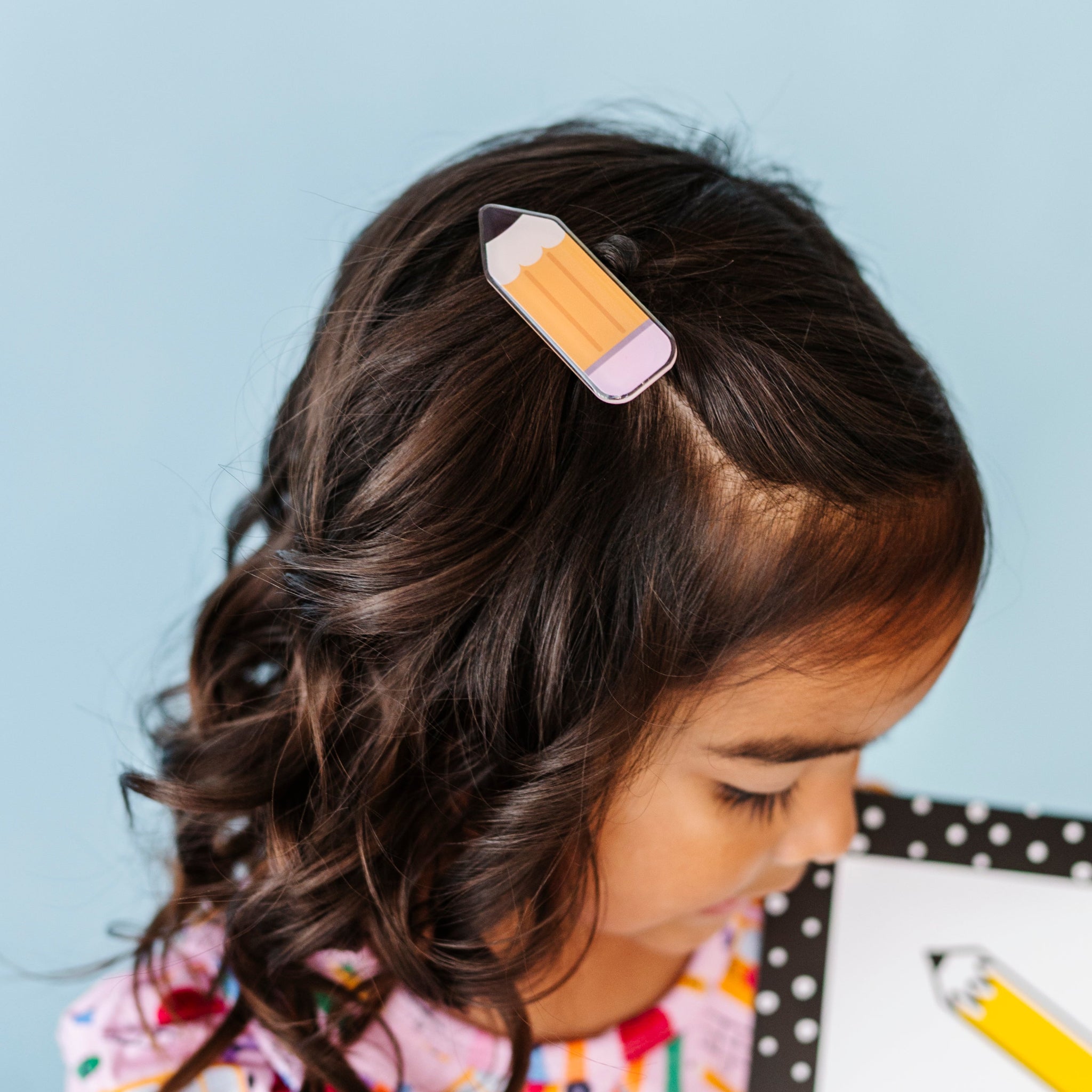 little girl in pencil shaped hair clip for back to school