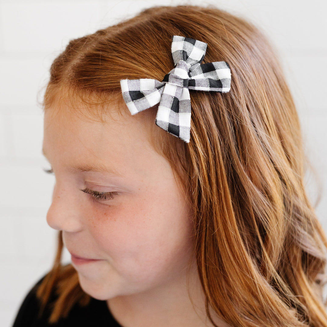 black and white gingham hair bow detail on little girl with red brown hair
