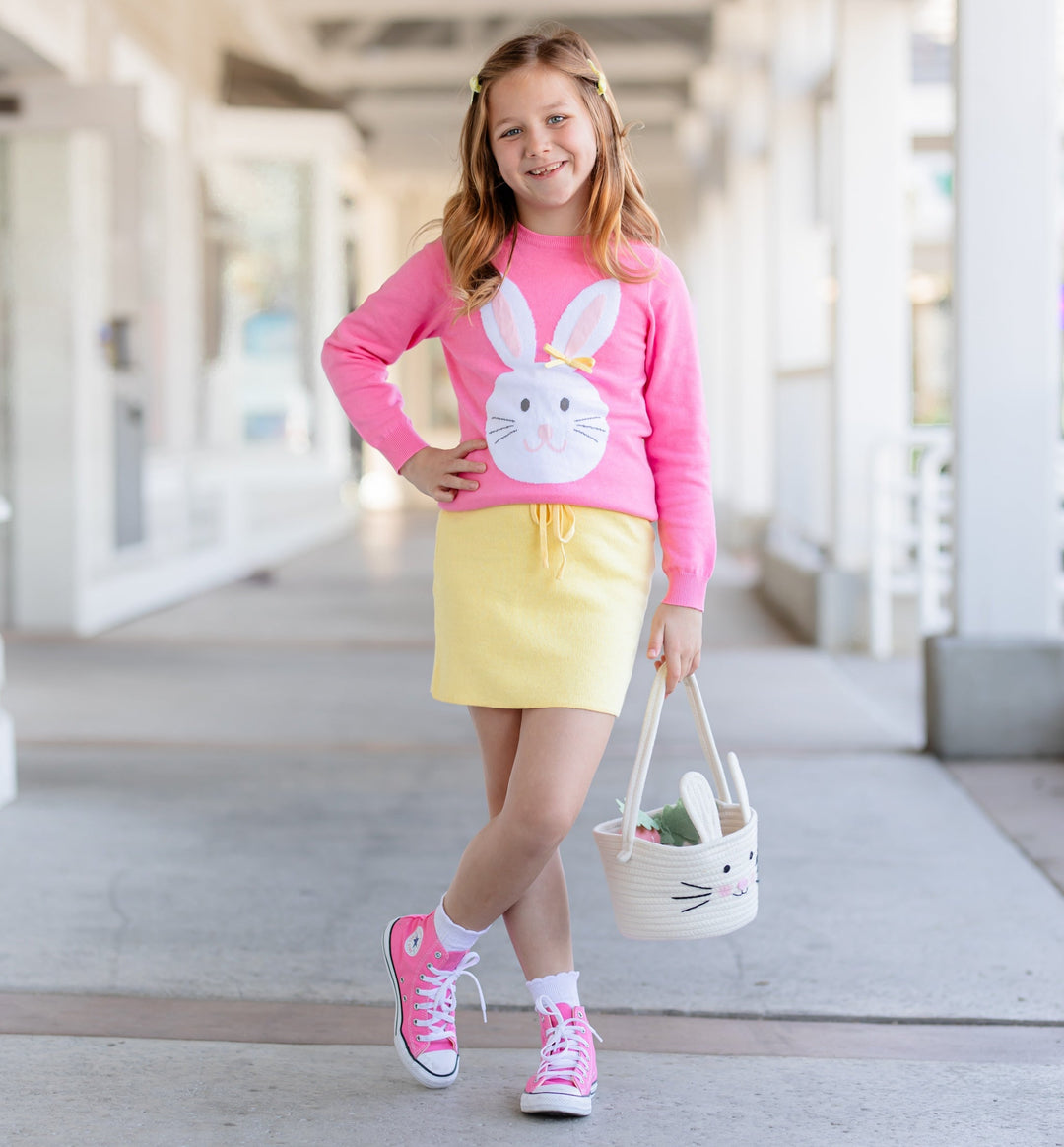 girl in pink easter bunny sweater with matching yellow knit skirt