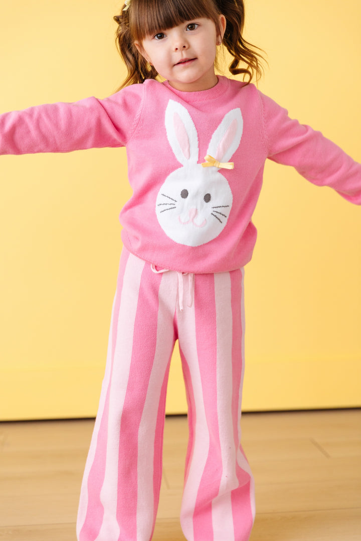 little girl in pink easter bunny pullover sweater and matching light and dark pink striped knit pants