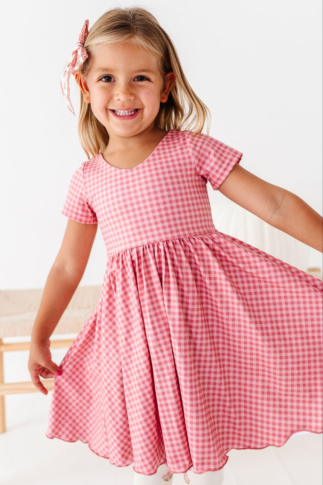 girl wearing tonal pink gingham twirl dress