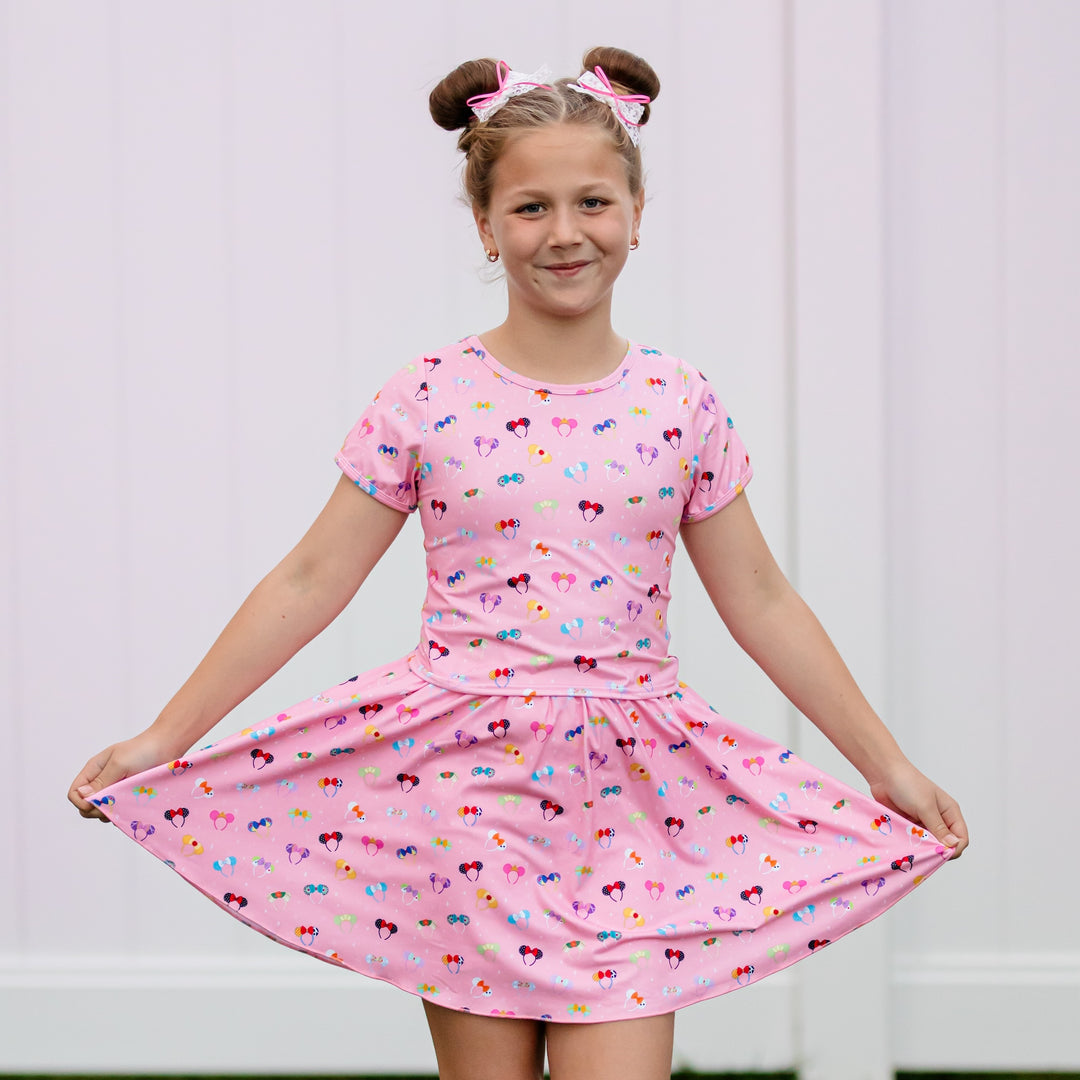 girls wearing disney inspired pink shirt with character mickey ears and matching skort with white lace bows and pink ribbon