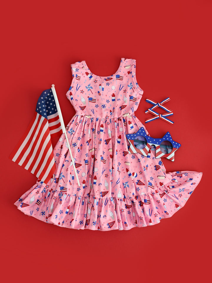 flatlay of girls pink 4th of july sleeveless twirl dress and matching accessories