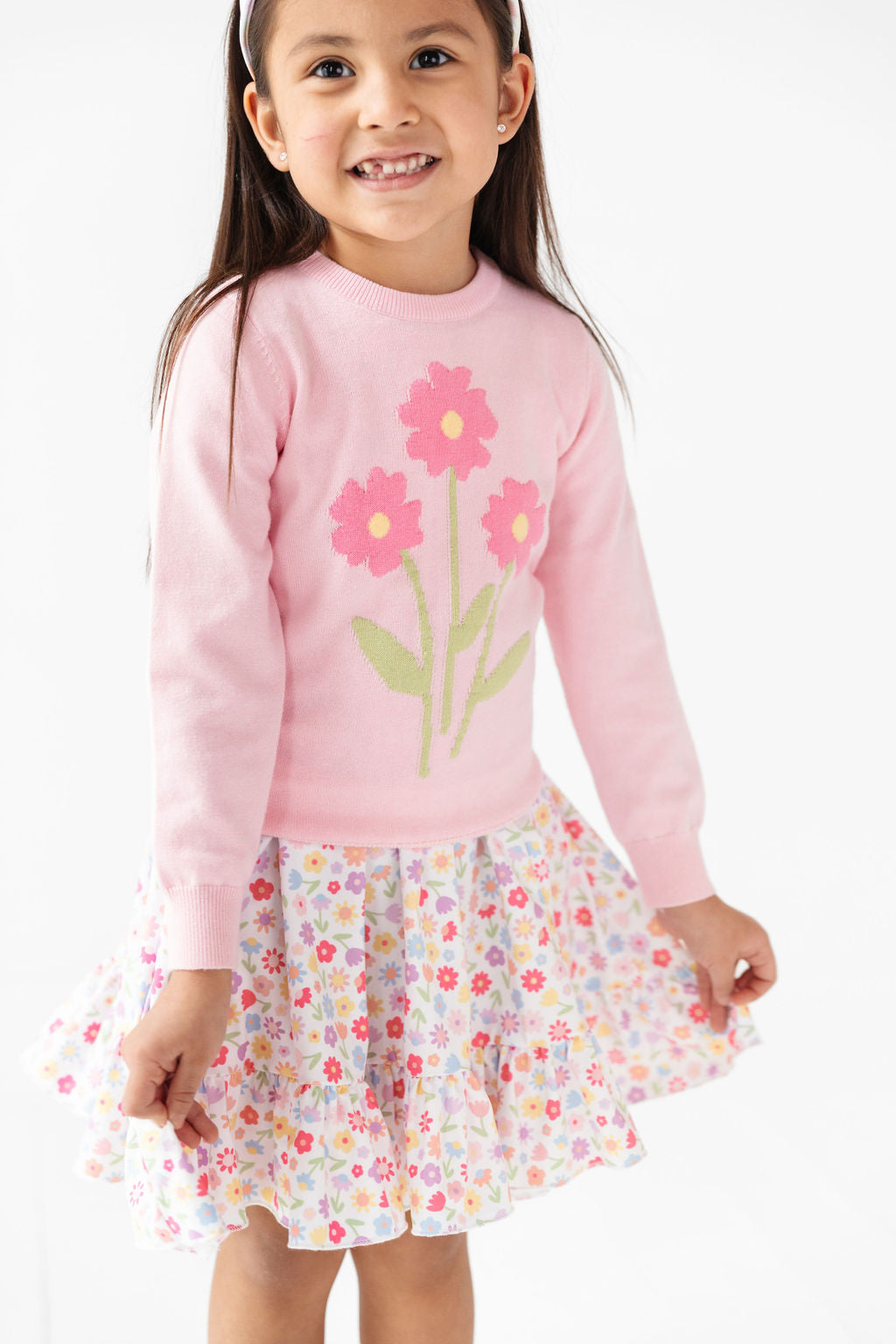 little girl in pink pullover knit sweater with floral design and coordinating white spring floral twirl dress