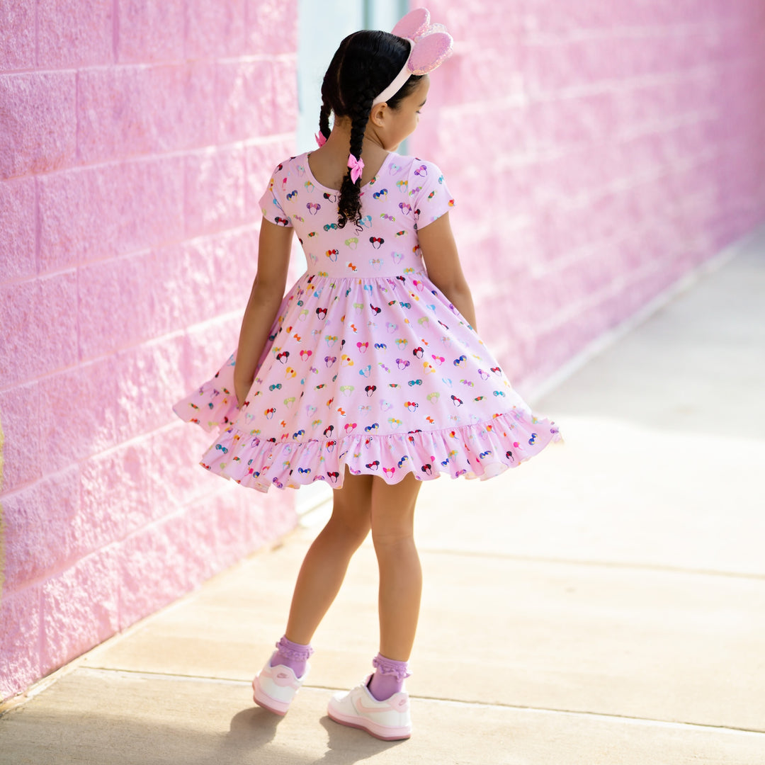 little girl twirling in pink disney character ears dress
