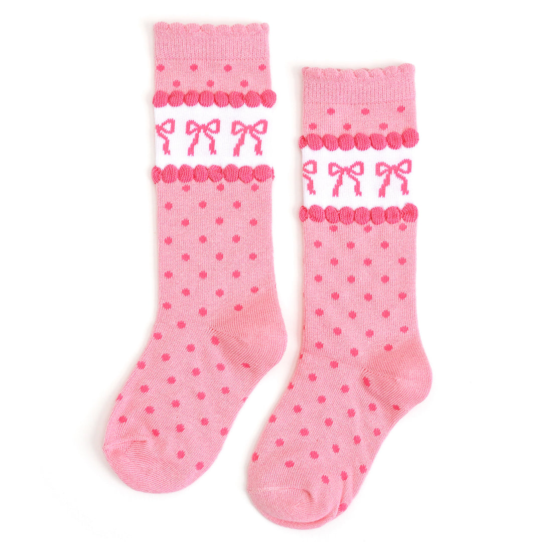 girl's scallop trimmed pink knee high socks with pink polka dots and wallpaper inspired bow design at the calf