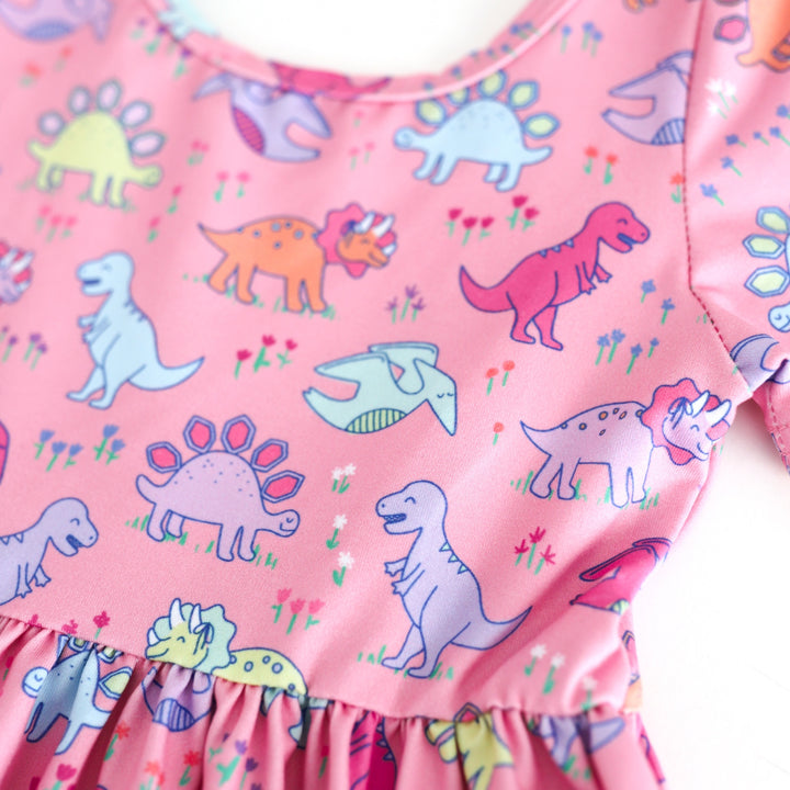 closeup of pink dino print on short sleeve twirl dress bodice