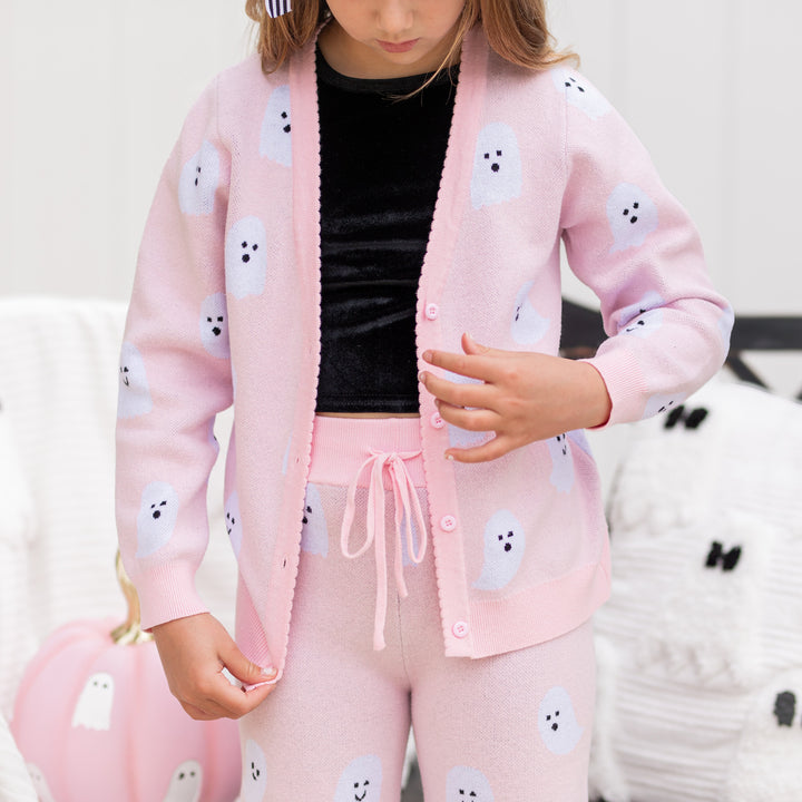 closeup of little girl in light pink button front v-neck cardigan with ghost design and matching sweater pants