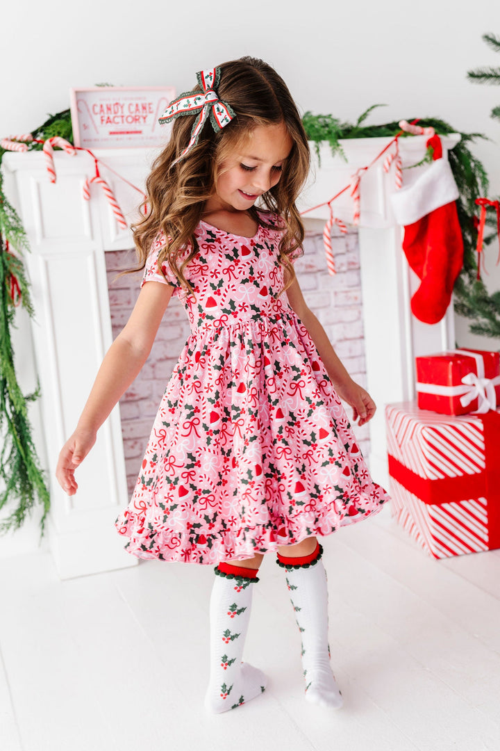 little girl twirling in pink christmas dress with candycanes and bows